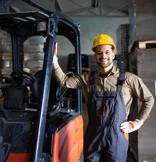 Forklift driver standing beside the machine