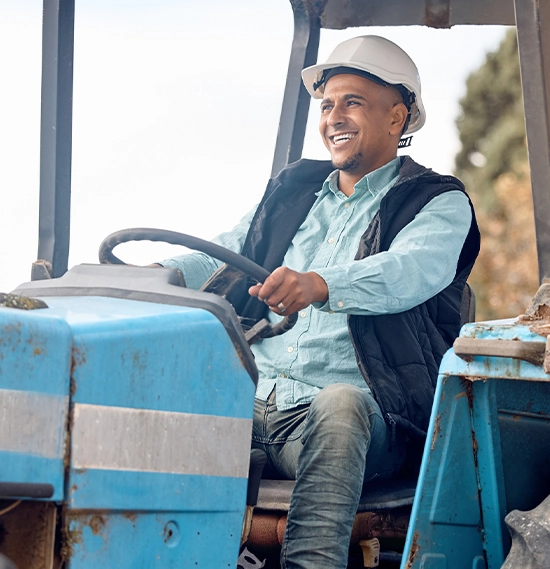 Construction worker riding a machinery tractor