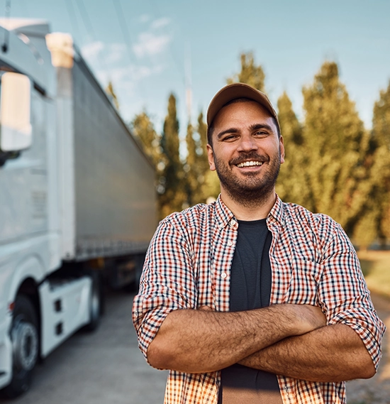 Truck driver with his vehicle in the background