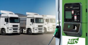 The image "Beat high diesel costs – invest in alternatives with affordable green Equipment Finance.jpg" shows a close-up of a green and white biofuel pump in the foreground. The pump features a digital display, a green nozzle in its holster, and prominent "BIO" logos stylized with green leaves. In the softly blurred background, a row of white semi-trucks is parked on a paved lot under a clear blue sky on a sunny day.